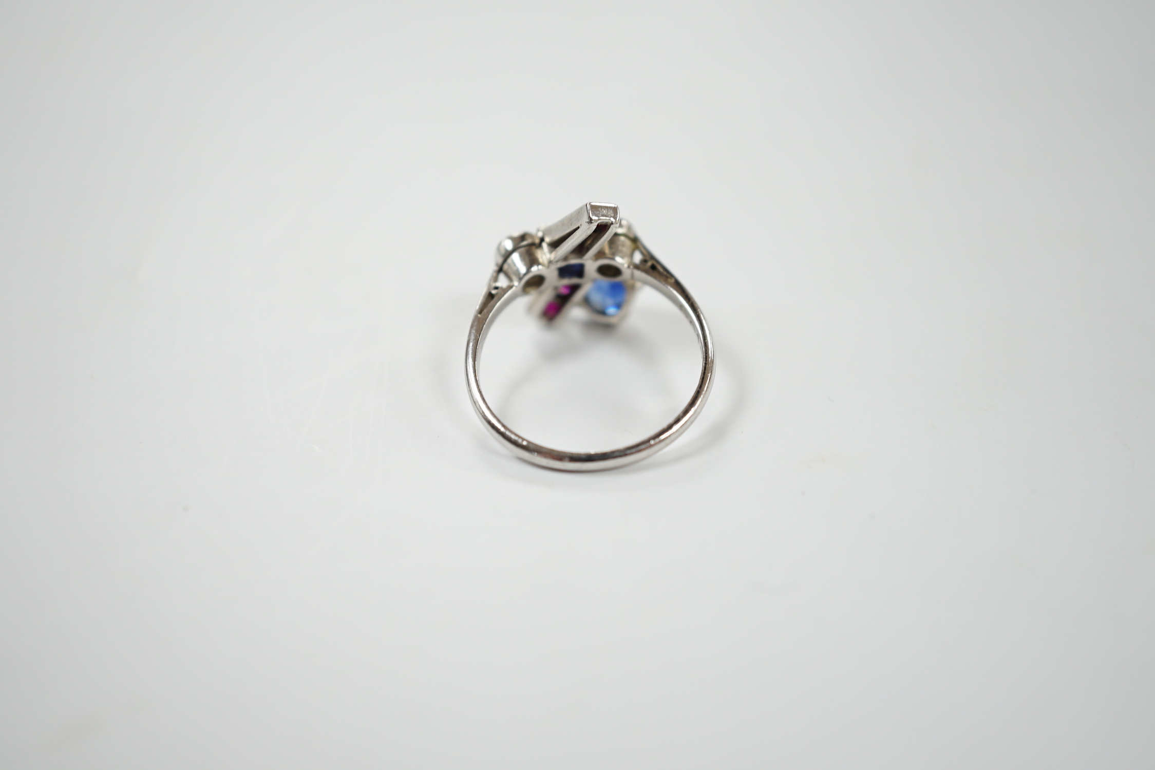 An unusual 1920's/1930's platinum, ruby, sapphire and diamond cluster set dress ring, of free form, the stones in a millegrain, claw or collet settings, size I, gross weight 3.7 grams.